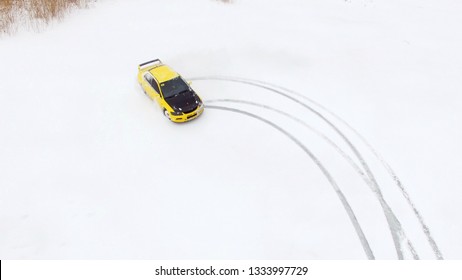 冬の雪に覆われた湖の氷のトラックで車を運転します。空撮。冬のスノーレーストラックでのスポーツカーレース。雪道でレースカーを運転する