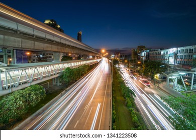 Spoorstation met verkeersopstopping en verhoogd treinmetrosysteem in spitsuur bij zonsondergang in Bangkok, vervoer met stadsconcept