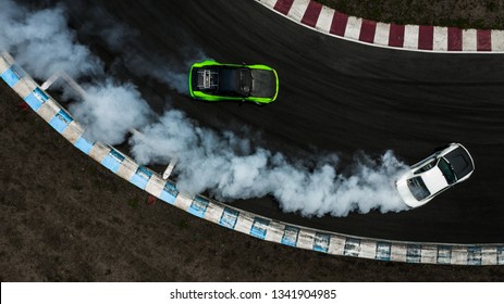 2 台の車が煙でレース トラックで戦いをドリフト、空撮 2 台の車がバトルをドリフトします。
