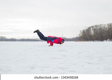 Un hombre de mediana edad practica yoga en un río helado. Mayurasana (postura del pavo real). Ulyanovsk, Rusia.