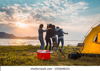 Groep vrouwen feesten en dansen met drankflessen genieten van reizen kamperen, wandelen in vakantietijd bij zonsondergang.