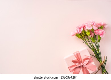 Mothers Day Design Concept - Draufsicht auf einen Haufen Nelke, Geschenkbox auf rosa Hintergrund für Hochzeit und Valentinstag mit Kopierraum für Mock-up