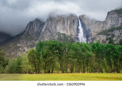 Yosemite Bridalveil water Fall, view from famous El Capitan rock across Yosemite Valley in Yosemite Valley National Park, California, USA, in summer with soft foggy clouds or fire smoke sky background