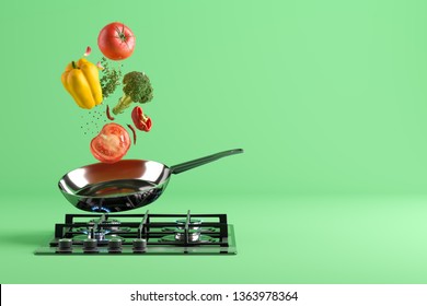 Sayuran berwarna segar beterbangan dari wajan stainless steel. Di bagian bawah - kompor masak dengan api menyala. Latar belakang studio hijau