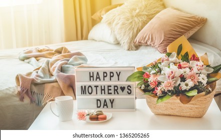 Chúc mừng ngày của mẹ. Một bó hoa đẹp với tách trà nóng trên bàn. Ăn sáng trên giường vào Ngày của Mẹ.