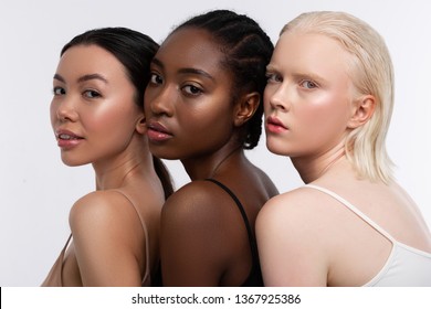 Three shades. Women with three shades of skin color having open shoulders while posing for diversity magazine