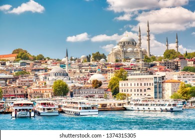 Touristische Besichtigungsschiffe in der Goldenen Hornbucht von Istanbul und Blick auf die Süleymaniye-Moschee mit dem Viertel Sultanahmet gegen blauen Himmel und Wolken. Istanbul, Türkei während des sonnigen Sommertages.