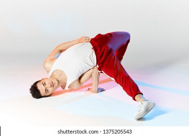 Geïsoleerde Koreaanse breakdancer training op witte achtergrond, Air Chair-element van downrock breakdance uitvoeren.