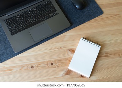 デスクトップのモックアップとビジネス デスクトップ シーン。ノート、スマートフォン、メモ帳、サボテンの植物を備えたノートブックのモックアップとオフィスの木製デスク。画面に販売グラフィックが表示された暗いノート。