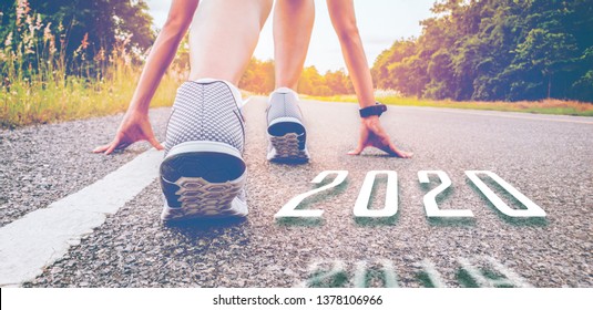 2020 symboliseert nummer de atletiek die nieuw jaar begint te veranderen, begin van mensen die op een straatweg rennen met zonsonderganglicht. Doel van succes de winnaar