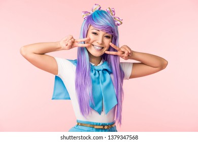 Vajzë e gëzueshme anime aziatike me parukë vjollce që tregon shenja paqeje të izoluara në rozë