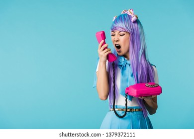 Angry asian anime girl screaming in handset isolated on blue