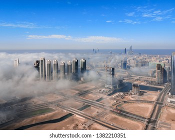 朝の霧雲に囲まれたアブダビの街並み、有名な塔や高層ビルの空撮