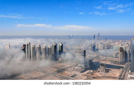 朝の霧雲に囲まれたアブダビの街並み、有名な塔や高層ビルの空撮