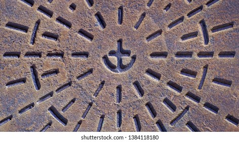 Símbolo de ancla fundido en una superficie metálica oxidada, herrajes decorados de grado comercial de hierro fundido, parte de la infraestructura de la gran ciudad.