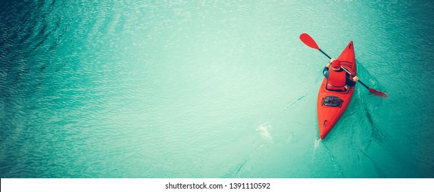 Kayak por el río. Hombres caucásicos en kayak rojo. Foto panorámica con espacio de copia del lado izquierdo. Tema de deportes acuáticos y recreaciones de verano.