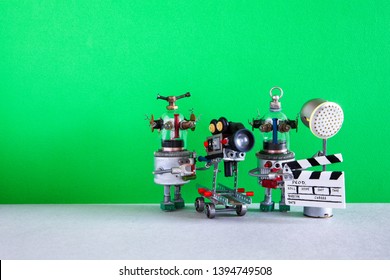 El asistente de foco de claqueta de cámara robot divertido graba comedia dramática con elementos de una película de terror, película de acción y aventuras. Película robótica detrás del escenario. Fondo verde