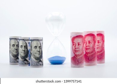 US dollar and Yuan banknote on with sand clock for trade war between United States and China which both countries battle by increase tax barrier and time out of meeting. Government and business.
