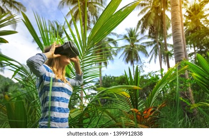 Woman in Virtual reality VR 3D headset   exploring the nature of tropical jungle