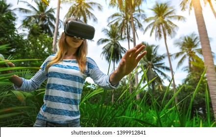 Woman in Virtual reality VR 3D headset   exploring the nature of tropical jungle