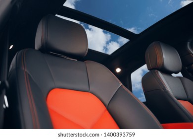 Tetto panoramico in vetro in auto durante una luminosa giornata estiva. Sedili sportivi rossi