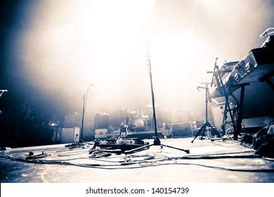 ドラムキット、ギター、マイクを備えた空の照明付きステージ