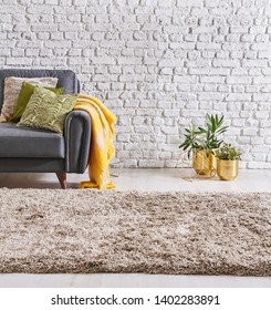 Estilo de cierre de moqueta, sofá de fondo moderno y objeto dorado con manta de almohada, pared de ladrillo blanco.