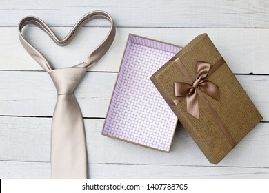 Geschenkbox und Krawatte auf Holzhintergrund.