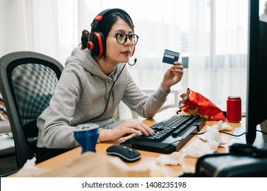 夏休みに自宅で若い怠惰な女子大生のオタクは、ゲーム ポイントを購入するオンライン e コマースを支払うクレジット カードを保持している学校から離れます。コンピューター インターネットを再生するヘッドフォンでアジアの女性オタク。