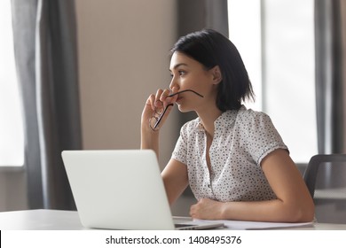 Mujer de negocios asiática ansiosa pensativa mirando a otro lado pensando en resolver problemas en el trabajo, preocupada mujer china joven seria preocupada por tomar una decisión difícil perdida en sus pensamientos reflejando sentarse con la computadora portátil