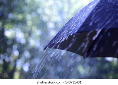 Tetesan hujan jatuh dari payung hitam