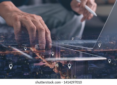 Bản đồ GPS, ghim vị trí địa chỉ trên ứng dụng di động. Phơi sáng kép của bàn tay con người bằng cách sử dụng máy tính bảng kỹ thuật số tìm kiếm địa điểm mục tiêu trên cảnh quan thành phố về đêm trong khi làm việc trên máy tính xách tay.