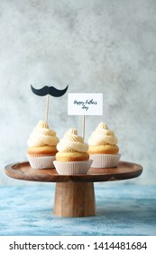 Stand with tasty cupcakes for Father's Day on grey background