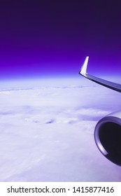 Zicht op wolken en lucht vanuit het vliegtuigraam tijdens de vlucht, fantastische paarse gloeiende kleur