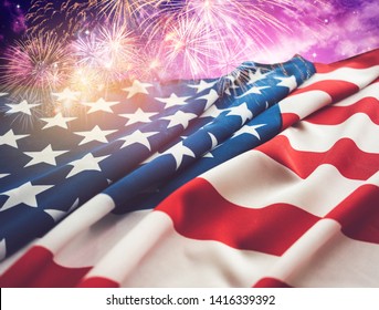 Bendera Amerika dan kembang api dengan latar langit malam.