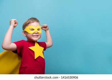 Siêu anh hùng nhí với chiếc áo choàng màu vàng và ngôi sao. Đứa trẻ mỉm cười hạnh phúc trong cặp kính đã sẵn sàng cho giáo dục. Thành công, khái niệm động lực. Trở lại trường. Doanh nhân nhỏ bị cô lập trên màu xanh, Siêu anh hùng cậu bé.