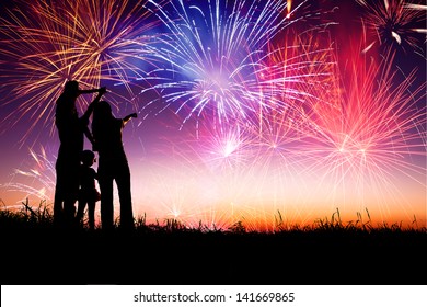 gia đình hạnh phúc đứng trên đồi và xem pháo hoa