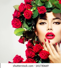 Portret lepotnega modnega modela z rdečimi vrtnicami, pričesko. Rdeče ustnice in nohti. Čudovita luksuzna ličila, pričeska in manikura v stilu Vogue.