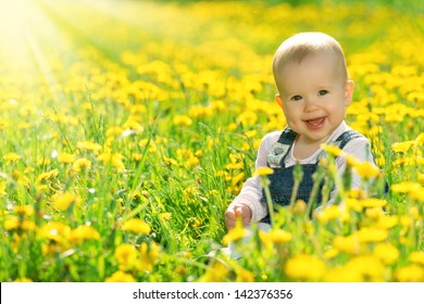 Mooi gelukkig klein babymeisje zittend op een groene weide met gele bloemen paardebloemen op de natuur in het park