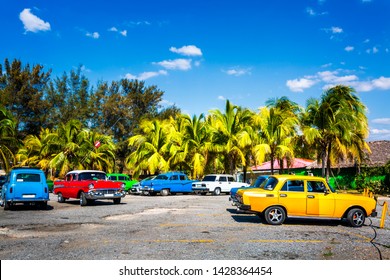 Coloridos viejos coches antiguos americanos / rusos estacionados cerca de la playa en Cienfuegos, Cuba, Las Antillas, el Caribe, América Central