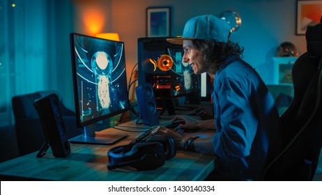 Professional Gamer Playing First-Person Shooter Online Video Game on His Powerful Personal Computer. Room and PC have Colorful Neon Led Lights. Young Man is Wearing a Cap. Cozy Evening at Home.