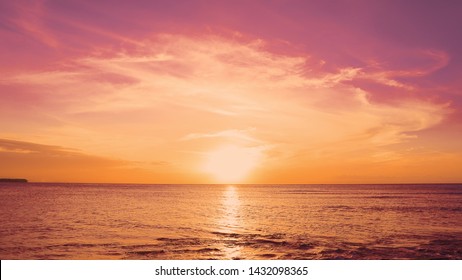 Red sundown sea. The coast of the Caribbean Sea, the yellow sun touches the horizon, beautiful orange clouds around the sun. Amazing view from the beach to the red sundown sea. Beautiful sea landscape