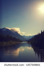 View of Mountains Alaska landscape reflected in wide river as viewed from the train.