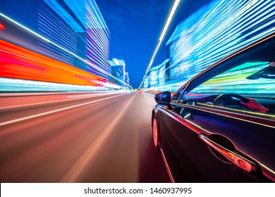 夜の街を移動する車の側面からの眺め、車が高速で光るぼかした道路。近代都市のコンセプト急速なリズム。