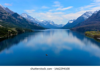 Schöner blauer See und Himmel in den kanadischen Rocky Mountains. An diesem Abend war der See ruhig und die Spiegelung der Berge und Wolken war herrlich.