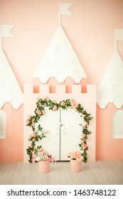 Sala giochi con castello rosa per bambini. Camera per bambini per una piccola principessa. Decorazioni per una festa per bambini. Appartamento per una piccola principessa con serratura rosa e porta bianca con fiori ricci.