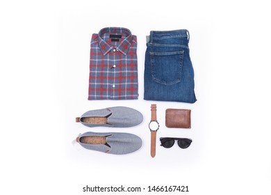 折り畳まれた長袖の格子縞のシャツとグレーの靴、時計、ブルー ジーンズ、時計、サングラス、白い背景の上の財布のトップ ビュー