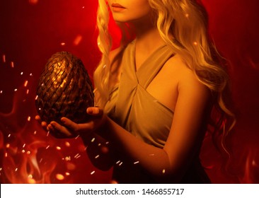 Schonende Silhouette der blonden Frau der Fantasiekunstwerk-Nahaufnahme ohne Gesichtshände, die großes Drachenei halten. Karneval Halloween Inspiration von Cosplay Daenerys Targaryen. Hintergrund rotes Feuergelb funkeln Licht