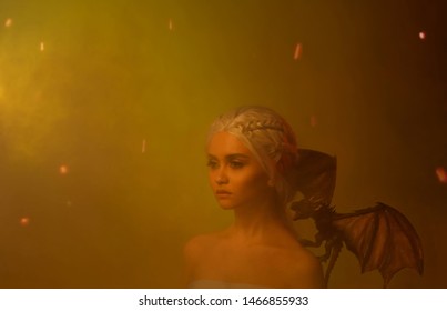 Kunstwerk Fantasie vrouw. Gezicht koningin in as rook vuur. elf prinses met kleine drakenvleugels. Kunstfoto-inspiratie van cosplay Daenerys Targaryen. Blond haar pruik kapsel vlecht Game of Thrones