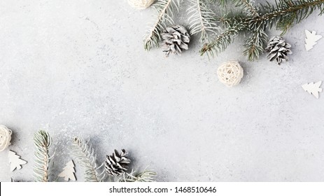 Christmas composition. Christmas fir tree branches, gifts, pine cones on wooden white rustic background. Flat lay, top view. Copy space. Banner backdrop